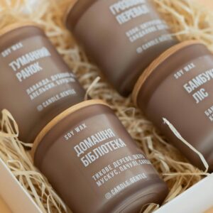 A set of four soy wax candles in earthy tones feature elegant packaging with unique scents.