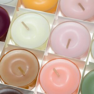 Colorful array of scented tea light candles in a decorative setting.